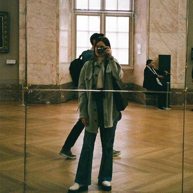 Larissa taking a photo in front of a large mirror