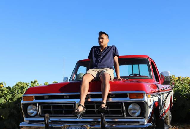 Vince on top of an old school red truck
