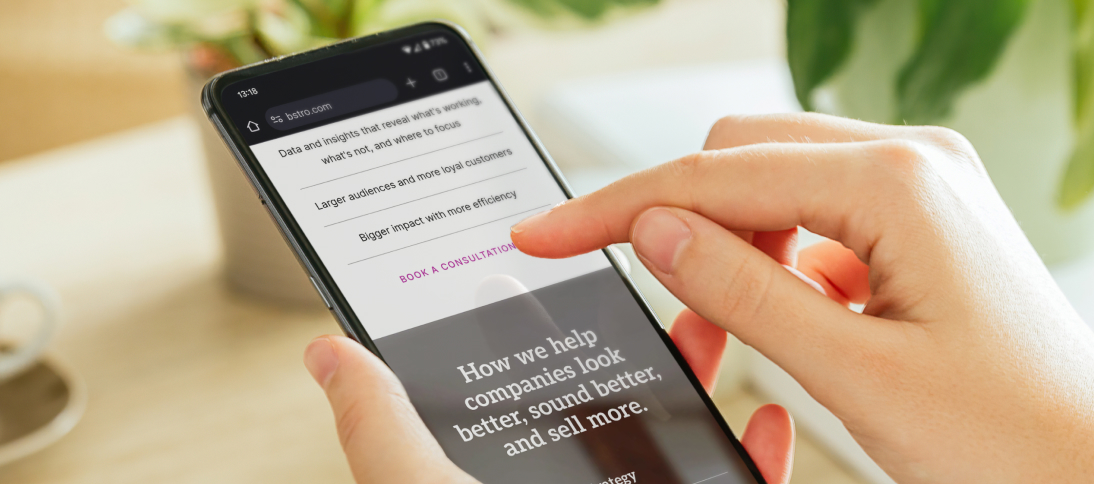 A woman holding a smartphone, gesturing tthey will be clicking on a website button.